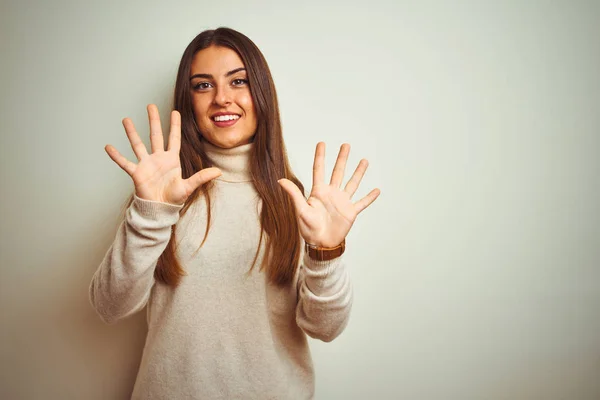 터틀넥 스웨터를 고립된 배경을 보여주고 손가락 10을 가리키며 자신감과 행복한 — 스톡 사진