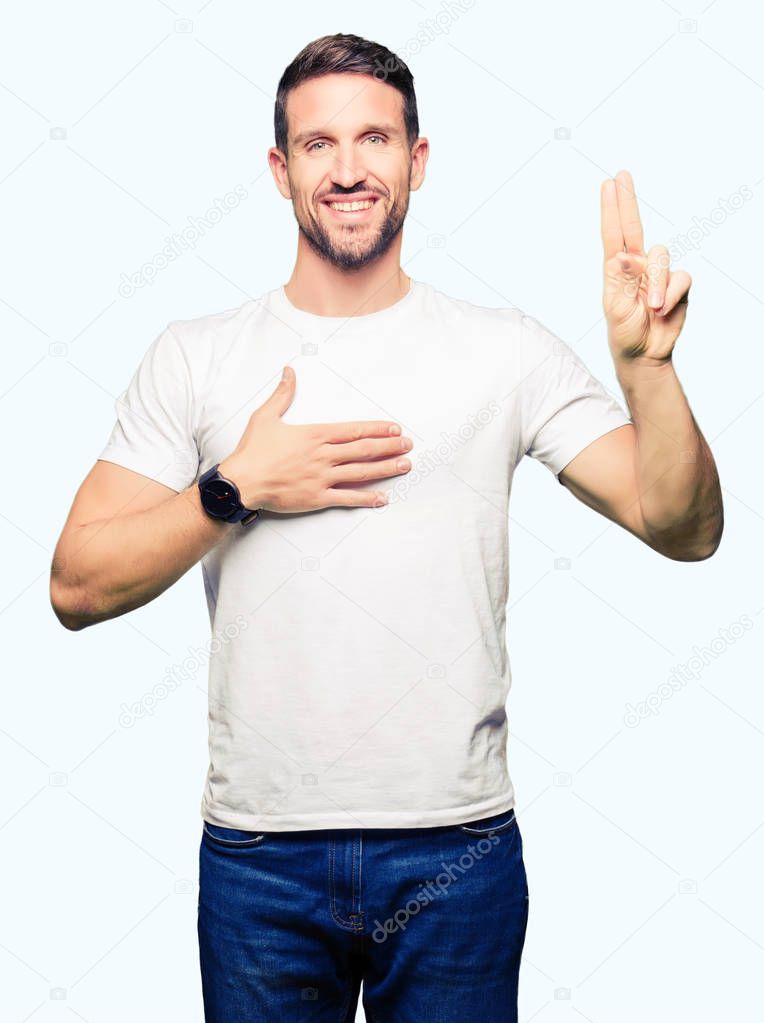Handsome man wearing casual white t-shirt Swearing with hand on chest and fingers, making a loyalty promise oath