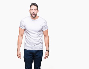 İzole arka plan korkuyor ve şok sürpriz ifade, korku ve heyecan yüz üzerinden Casual beyaz t-shirt giyen genç adam.