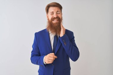 Genç kızıl saçlı İrlandalı işadamı diş ağrısı veya diş üzerinde diş hastalığı nedeniyle ağrılı ifade ile el ile ağız dokunmadan izole beyaz arka plan üzerinde duran takım elbise giyiyor. Diş hekimi konsepti.