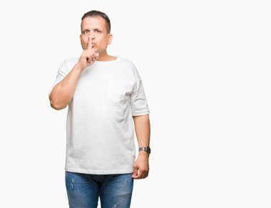 Orta yaş Arap adam wearig beyaz t-shirt üzerine arka plan dudaklarında parmak ile sessiz olmanı izole. Sessizlik ve gizli kavramı.