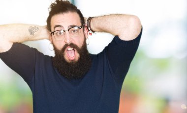 Genç hipster adam uzun saçlı ve gözlüklü deli ve baş, korkuyor ve açık ağzı ile şok sürpriz elleriyle korkuttu sakal