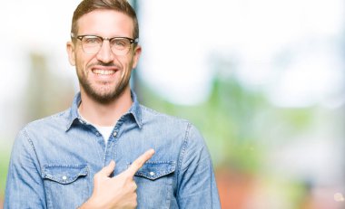 Yakışıklı adam neşeli bir gülümseme ile el ve parmak kadar yan yüzünde mutlu ve doğal ifade ile işaret yüz ile gözlüklü