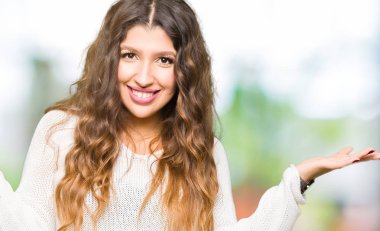 Eller beyaz kazak gülen gösteren her iki giyen genç güzel kadın açık avuç içi, sunmak ve reklam karşılaştırma ve denge