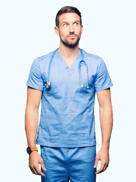 Bello Medico Uomo Indossa Uniforme Medica Sfondo Isolato Sorridente Guardando — Foto Stock