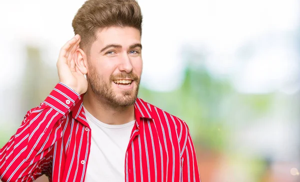 Pemuda Tampan Mengenakan Kemeja Merah Tersenyum Dengan Tangan Atas Telinga — Stok Foto