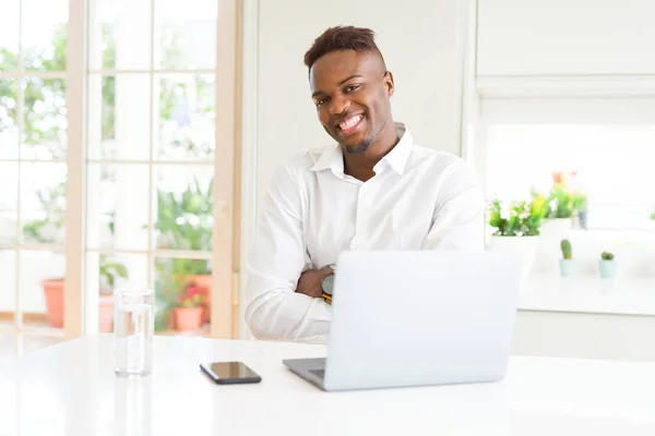 カメラを見て腕を組んで微笑むラップトップの幸せな顔を使用して働くアフリカ系アメリカ人のビジネスマン ポジティブな人 — ストック写真
