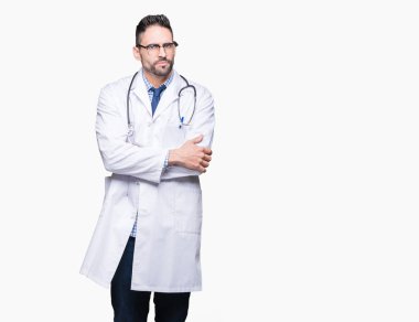 Handsome young doctor man over isolated background skeptic and nervous, disapproving expression on face with crossed arms. Negative person. clipart