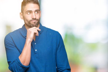 Yakışıklı delikanlı çene düşünme hakkında soru, dalgın ifade üzerine el ile izole arka plan üzerinde. Düşünceli yüzüyle gülümsüyor. Şüphe kavramı.