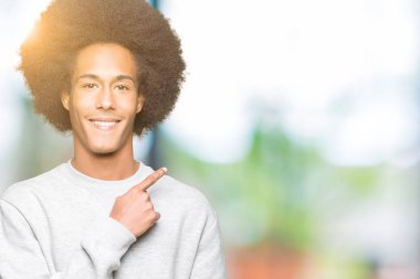 Sportif kazak neşeli bir gülümseme ile el ve parmak kadar yan yüzünde mutlu ve doğal ifade ile işaret yüz giyen afro saçlı genç Afro-Amerikan adam