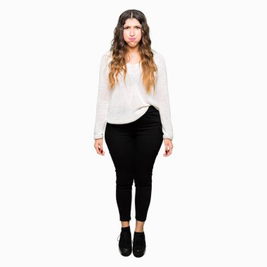 Komik surat ile yanakları şişirme beyaz kazak giyen genç güzel kadın. Ağız ile hava, deli ifade şişirilmiş.