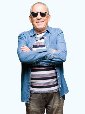 Denim ceket ve güneş gözlüğü mutlu yüz çapraz silah kameraya bakarak ile gülümseyen giymiş yakışıklı komuta sizde. Olumlu bir kişi.