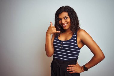 Eseksüel transseksüel kadın izole beyaz arka plan üzerinde çizgili t-shirt giyen telefonda konuşurken gibi el ve parmakları ile telefon jest yapıyor gülümseyerek. İletişim kavramları.