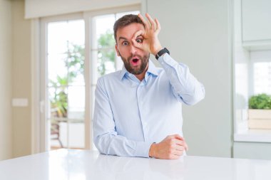 Yakışıklı iş adamı ok jest yapıyor şaşırmış yüzü ile şok, göz parmaklarından bakarak. İnanmayan ifade.