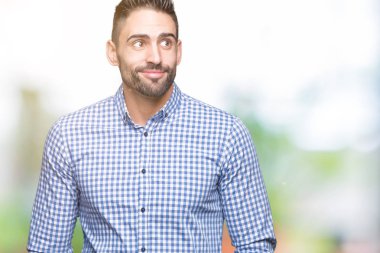 Yakışıklı delikanlı görünümlü yan ve dik dik bakma uzağa düşünce gülümseyen izole arka plan üzerinde.