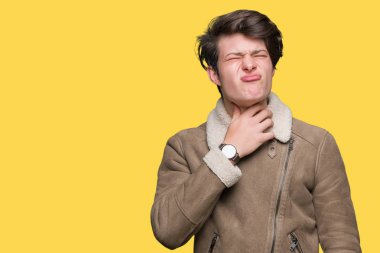 İzole arka plan üzerinde kış ceket giyen genç yakışıklı adam ağrılı boyun dokunmadan, grip için boğaz ağrısı, kesek ve enfeksiyon