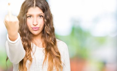 Beyaz kazak gösteren orta parmak, kaba ve kaba lanet ifade kapalı giyen genç güzel kadın