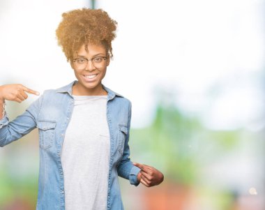 Güzel genç Afro-Amerikan kadın yüzünde gülümseme ile kendinden emin görünüyorsun, kendini gururlu ve mutlu parmakları ile işaret izole arka plan üzerinde gözlük.