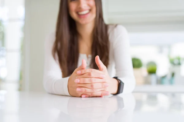 Close up of woman smiling with cross hands over white table — стоковое фото