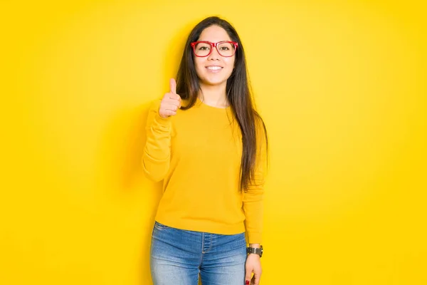 Schöne Brünette Frau Mit Roter Brille Über Gelbem Isolierten Hintergrund — Stockfoto