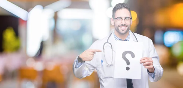 Guapo Joven Doctor Hombre Sosteniendo Papel Con Signo Interrogación Sobre — Foto de Stock