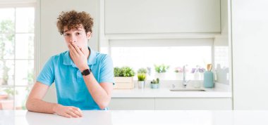 Evde genç yakışıklı adam geniş çekim el ile ağız kapsayan yorgun esneme sıkılmış. Huzursuz ve uykululuk.