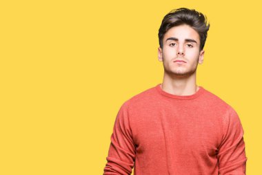 İzole arka plan gevşek yüzünde ciddi bir ifade ile genç yakışıklı adam. Basit ve doğal kameraya bakıyor.