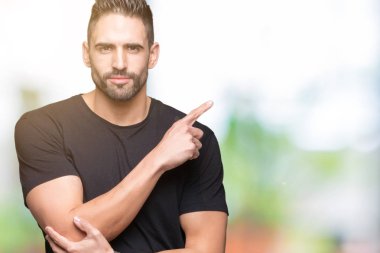 Yakışıklı delikanlı izole üzerinden reklam, ciddi ve sakin yüz gösterilen yan el parmak ile işaret arka plan