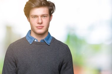 Genç yakışıklı zarif adam yüzünde ciddi bir ifade ile izole arka plan gevşek. Basit ve doğal kameraya bakıyor.