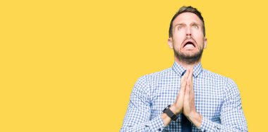 Yakışıklı iş adamı yalvarıyor ve umut ifade yüzünde çok duygusal ve endişe ile birlikte elleriyle dua kravat takıyor. Bağışlanmak. Din kavramı.