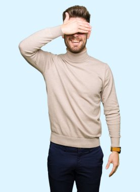 Gülümsüyor ve gözleri için sürpriz kapsayan yüz el ile gülüyor gözlüklü genç yakışıklı iş adamı. Kör kavramı.