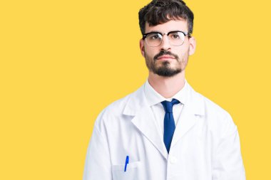 Üzerinde beyaz önlük giyen genç profesyonel bilim adam arka plan gevşek yüzünde ciddi bir ifade ile izole. Basit ve doğal kameraya bakıyor.