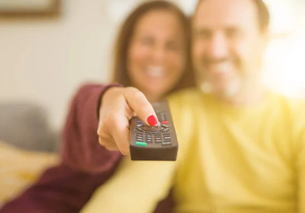 Romantiska medelålders par titta på tv i soffan hemma — Stockfoto