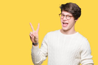 Mutlu yüz zafer işareti yaparken kameraya göz kırpıyor ile gülümseyen izole arka plan üzerinde gözlük takan yakışıklı delikanlı. İki numaralı.