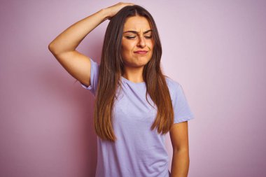 İzole edilmiş pembe arka planda duran sıradan tişörtler giyen genç ve güzel bir kadın soru sormayı merak ediyor. Şüpheyle kararsız, kafa kafaya düşünerek. Düşünceli kavram.