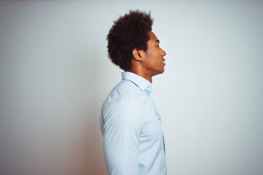 Yan bakarak izole beyaz arka plan üzerinde zarif gömlek giyen afro saçlı genç afro-amerikan adam, kendine güvenen gülümseme ile doğal yüz ile profil poz dinlenmek.