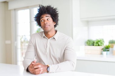 Afrika kökenli Amerikalı adam evde görünümlü yan ve dik dik bakma uzağa düşünce gülümseyen.