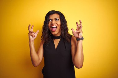 Transseksüel transseksüel zarif iş kadını izole sarı arka plan deli ve deli üzerinde duran bağırarak ve agresif ifade ve kolkaldırdı ile bağırıyor. Hayal kırıklığı kavramı.