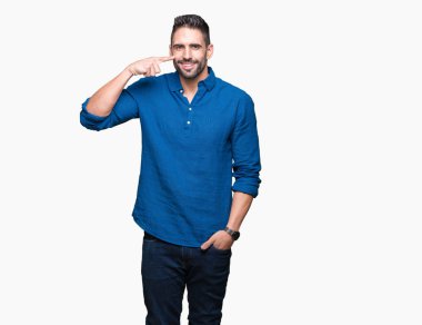 İzole genç yakışıklı adam arka plan işaretçi el parmak yüz ve burun, neşeli gülümseyen