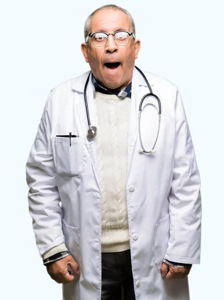 英俊的高级医生男子穿着医疗外套在休克的脸 看起来怀疑和讽刺 惊讶与张开嘴 — 图库照片