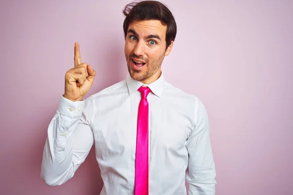 年轻英俊的商人穿着衬衫和领带站在孤立的粉红色背景上 指着手指与成功的想法 退出和快乐 — 图库照片
