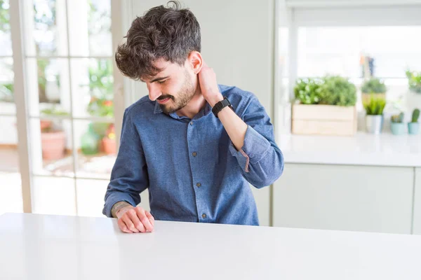 Ung Man Bär Casual Skjorta Sitter Vitt Bord Lidande Nacken — Stockfoto