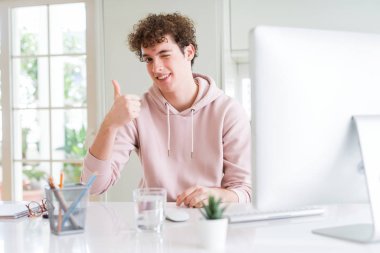 Ok işareti, başparmak ile parmak, mükemmel işareti yapıyor kocaman bir gülümseme ile bilgisayar mutlu kullanan genç öğrenci adam