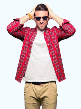 Yakışıklı erkek güneş gözlüğü çünkü umutsuz ve stresli baş ağrısı acı acı moda giyen ve migren. Ellerini kafasına.