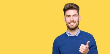 Genç yakışıklı Bussines adam yapıyor mutlu thumbs yukarı jest ile el. Başarı gösteren kameraya bakarak ifadeyi onaylama.