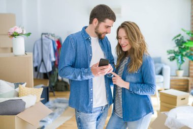 Genç çift cardb etrafında akıllı telefon kullanarak yeni bir eve hareket