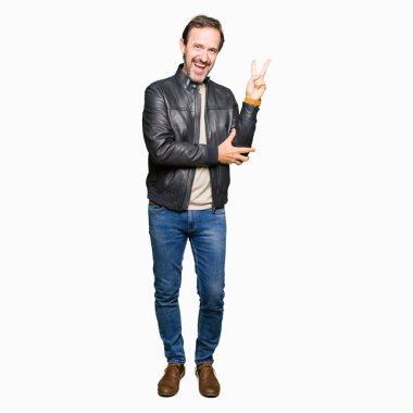 Mutlu yüz zafer işareti yaparken kameraya göz kırpıyor ile gülümseyen siyah deri ceket giyen orta yaş yakışıklı adam. İki numaralı.