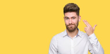 Genç yakışıklı iş adam çekim ve öldürmek kendini el ve parmaklara baş, intihar jest işaret.