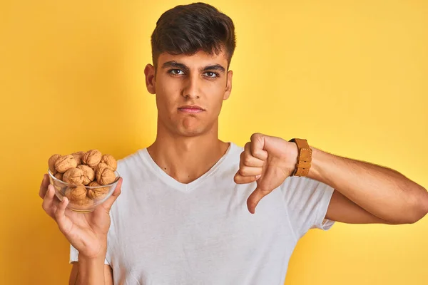 Young Indian Man Holding Bowl Walnuts Standing Isolated Yellow Background — Stock Photo, Image
