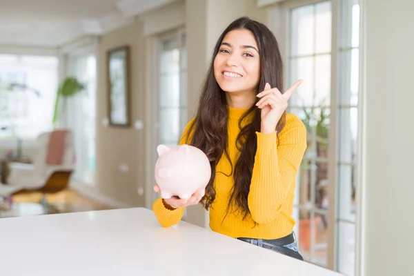 Young Woman Holding Piggy Bank Very Happy Pointing Hand Finger — Stock Photo, Image
